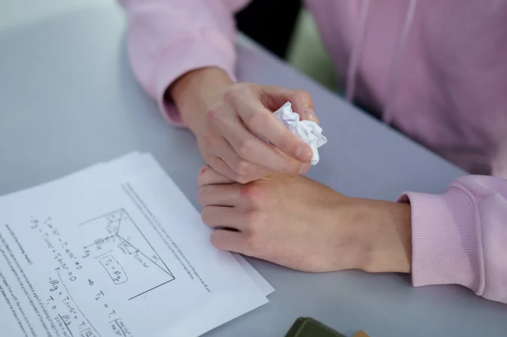 Crumpled math test in hands of stressed student Crumpled math test in hands of stressed student