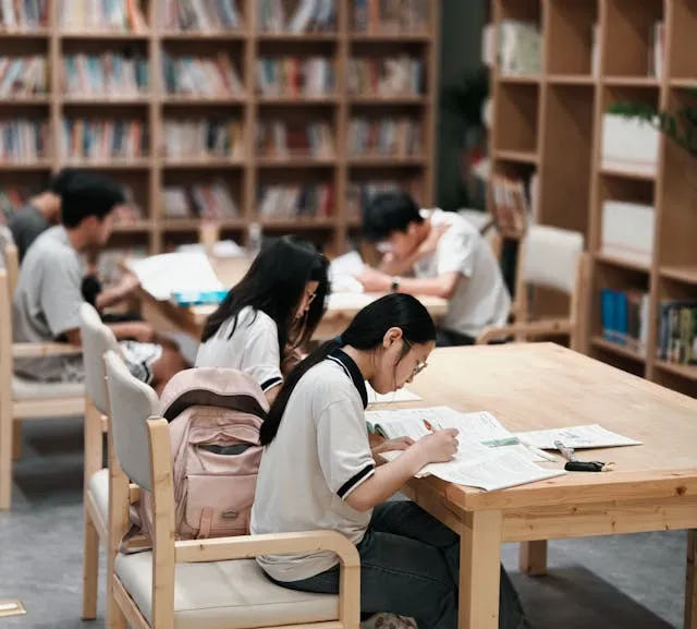 Students studying at tables in library