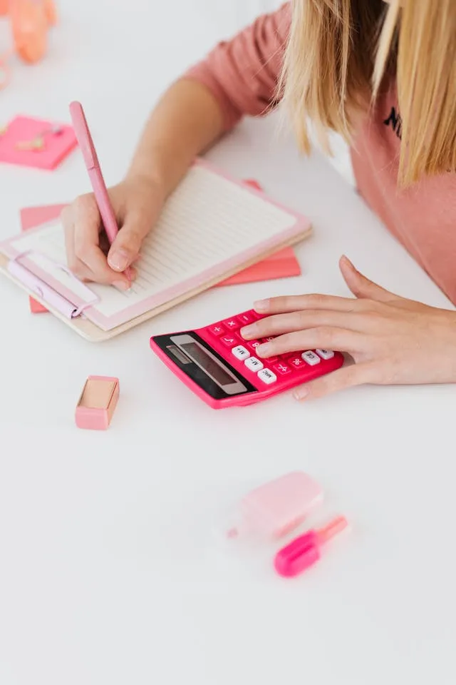 Student using calculator and writing notes